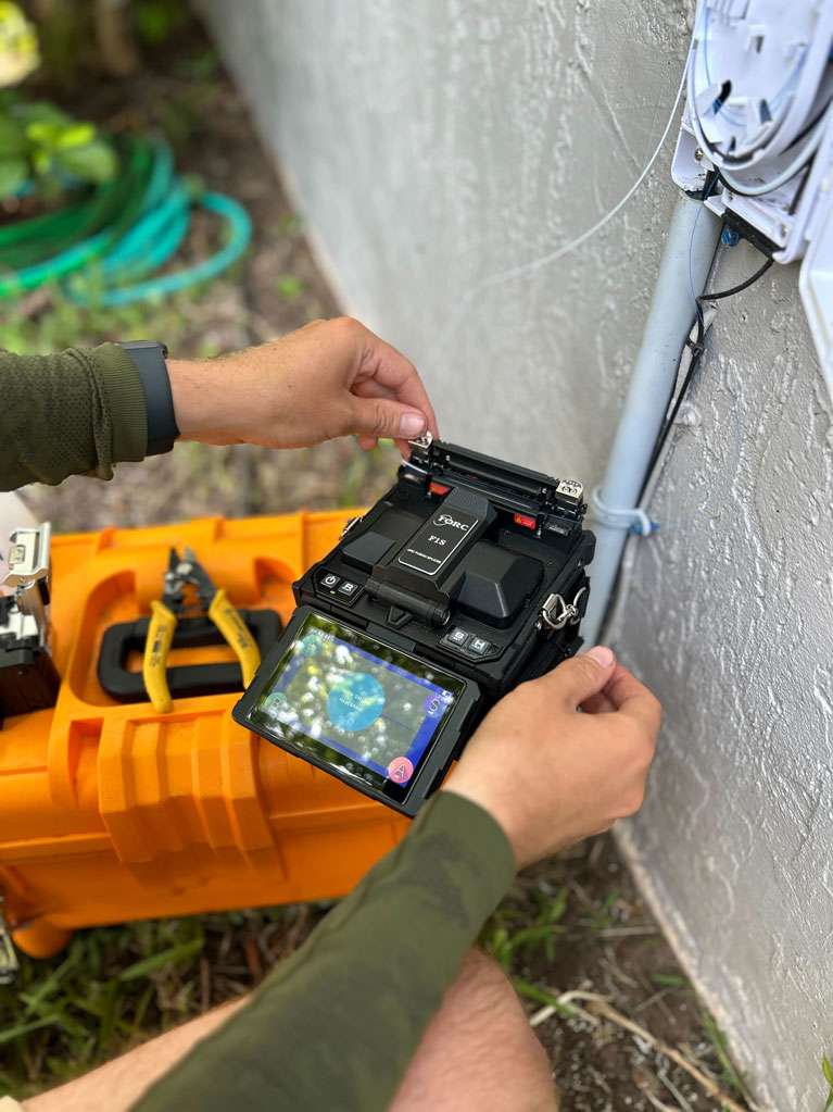 Photo of Wire 3 tech setting up the Optical Network Terminal (ONT)